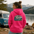 Model wearing Camberline pink van life hoodie showing Van Life Lakeside Escape vintage retro campervan lake and camping badge on back