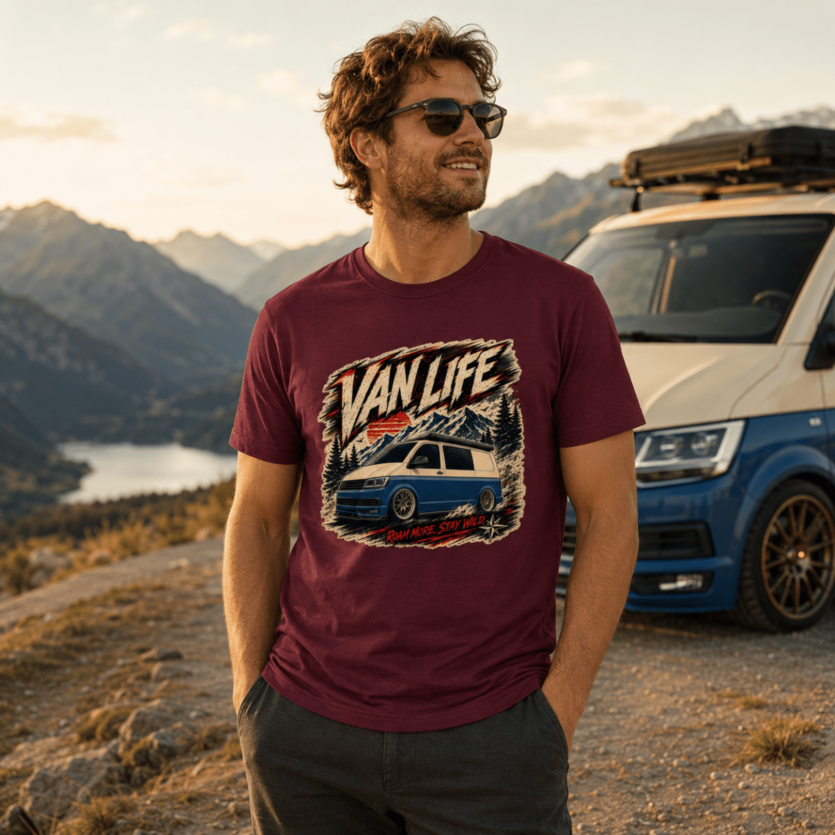 Man wearing a 'Van Life' t-shirt with a car graphic, standing in front of a scenic mountain landscape.