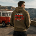 Model wearing Camberline olive van life hoodie showing VanLife Live It red and cream retro campervan side profile graphic on back