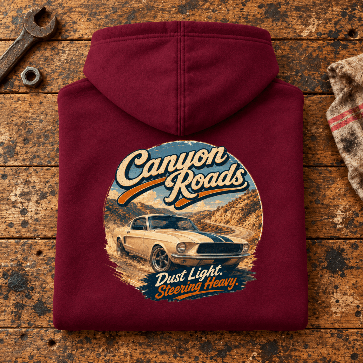 Canyon Roads Muscle Fastback American Drive Graphic Hoodie — Burgundy, folded back main hero on a worn automotive workbench – car-hd-0056