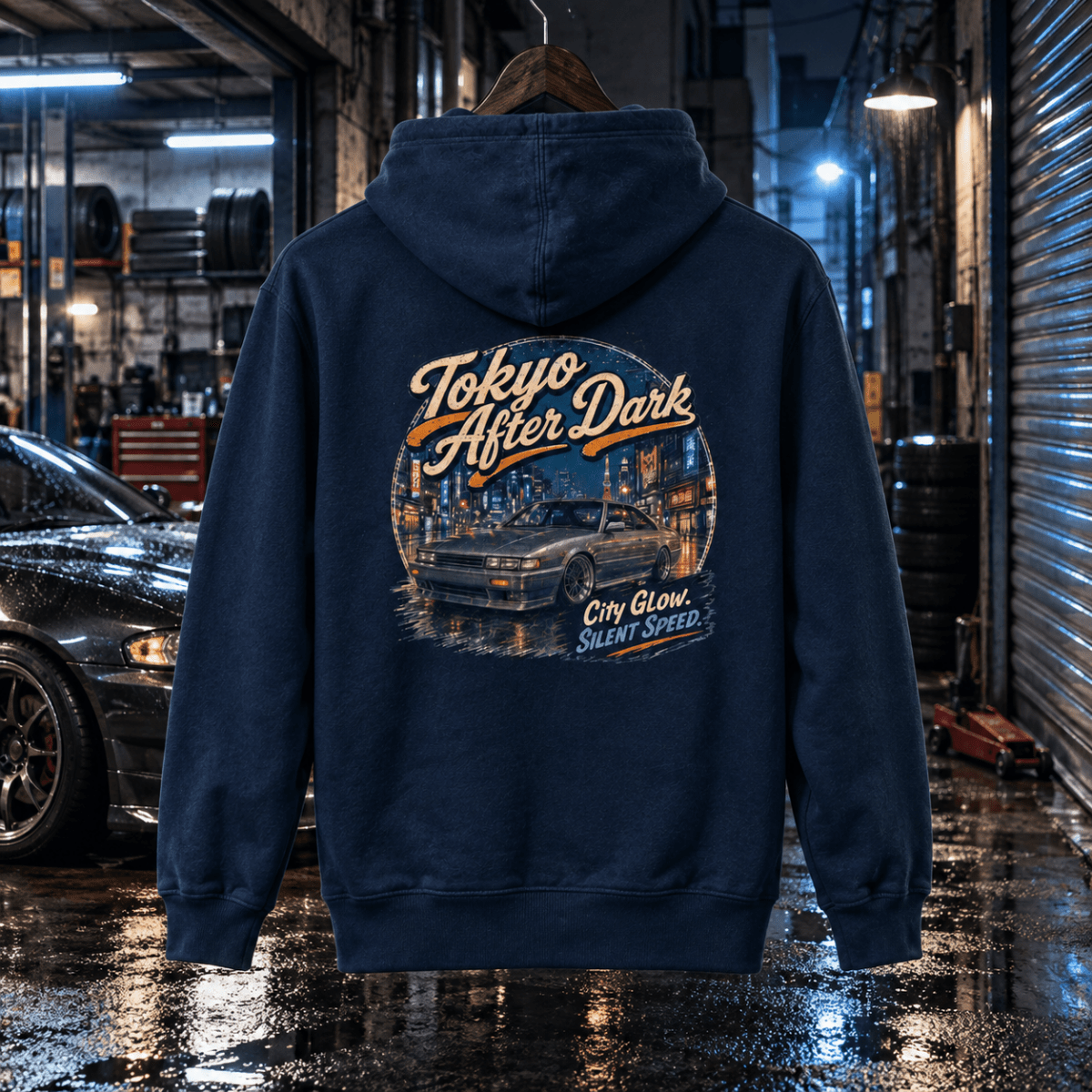 Tokyo After Dark navy hoodie back in a gritty rain-soaked tuning garage