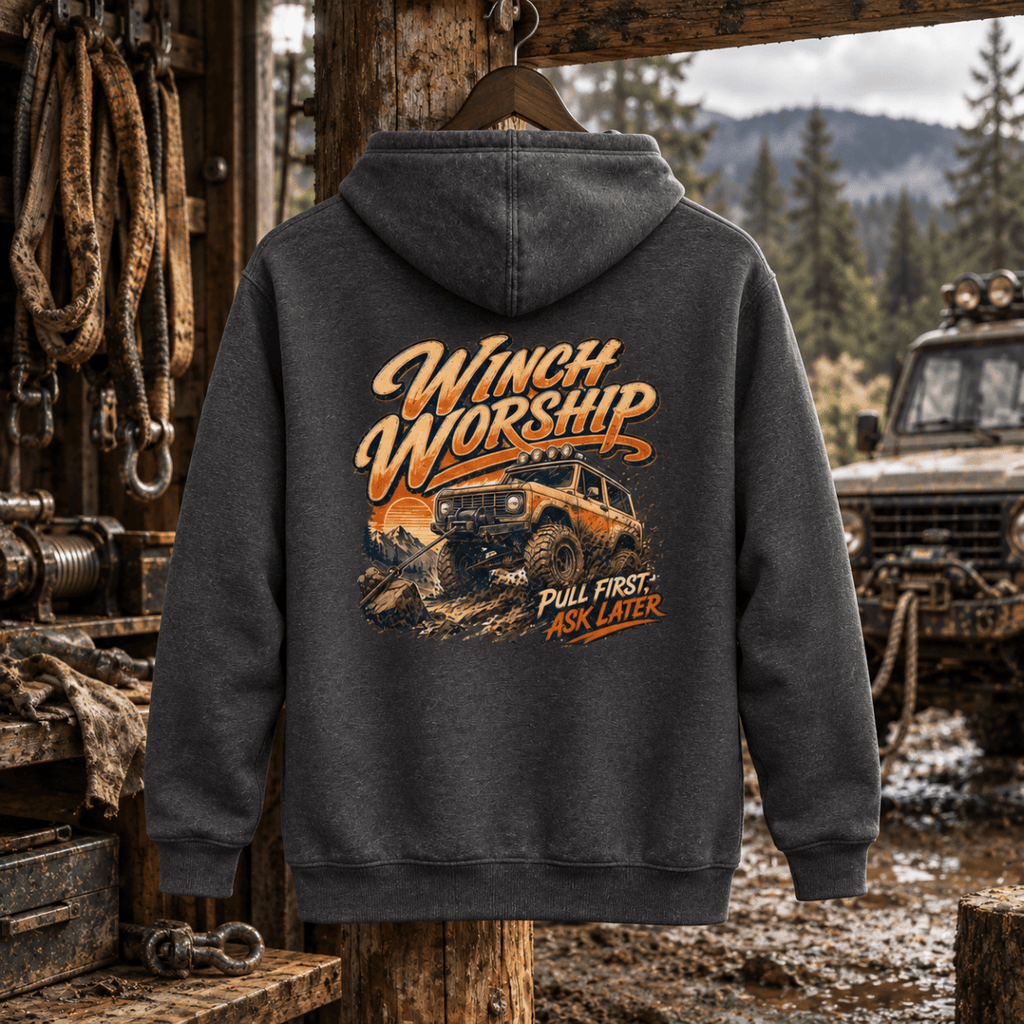 Winch Worship charcoal hoodie back in a gritty woodland recovery workshop