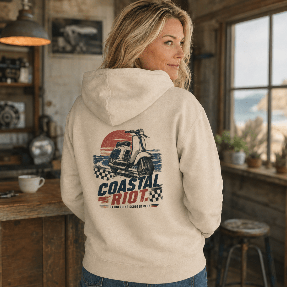 Model wearing a cream Coastal Riot vintage scooter graphic hoodie, back print view