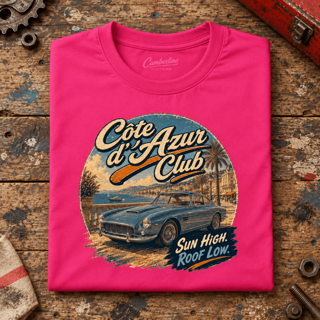 Cote D'Azur Classic GT French Riviera Graphic T-Shirt — Hot Pink, folded front main hero on a worn automotive workbench – car-ts-0055