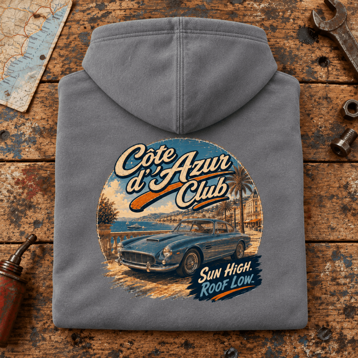 Cote D'Azur Classic GT French Riviera Graphic Hoodie — Storm Grey, folded back main hero on a worn automotive workbench – car-hd-0055