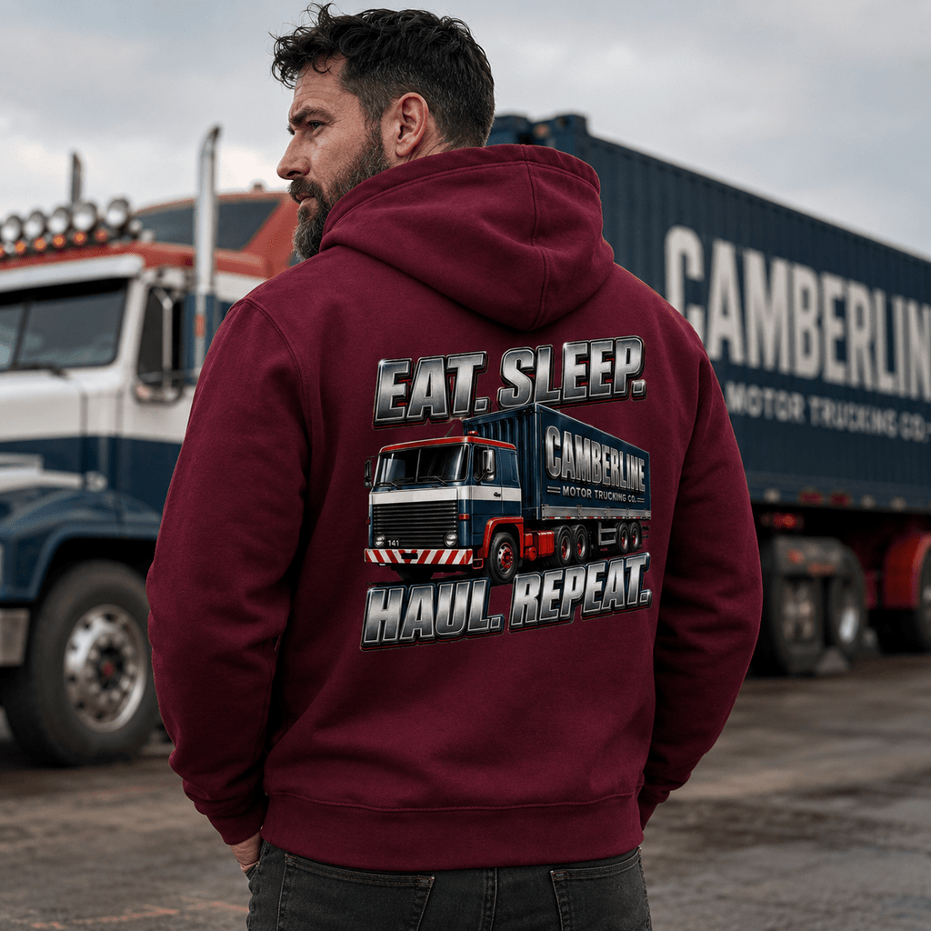 Man wearing a maroon hoodie with 'Camberlin' truck design and text in front of trucks.