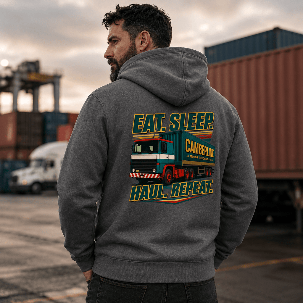 Person wearing a hoodie with a truck graphic and text in an industrial setting