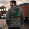 Person wearing a hoodie with a truck graphic and text in an industrial setting