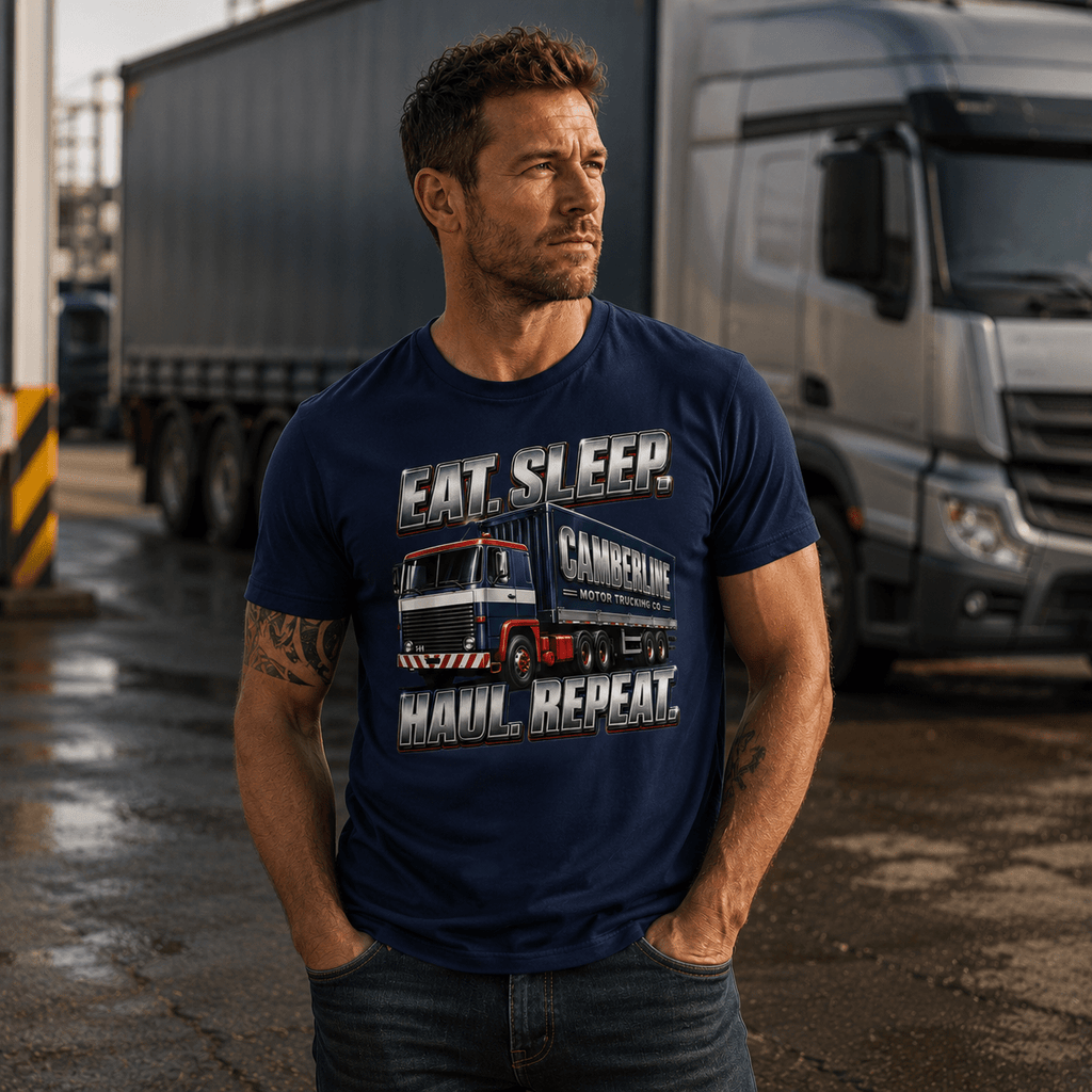 Male model wearing navy Eat Sleep Haul Repeat Camberline lorry t-shirt standing in a wet transport yard with artic lorries in the background