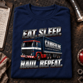 Navy Eat Sleep Haul Repeat lorry T-shirt folded on a gritty night depot desk