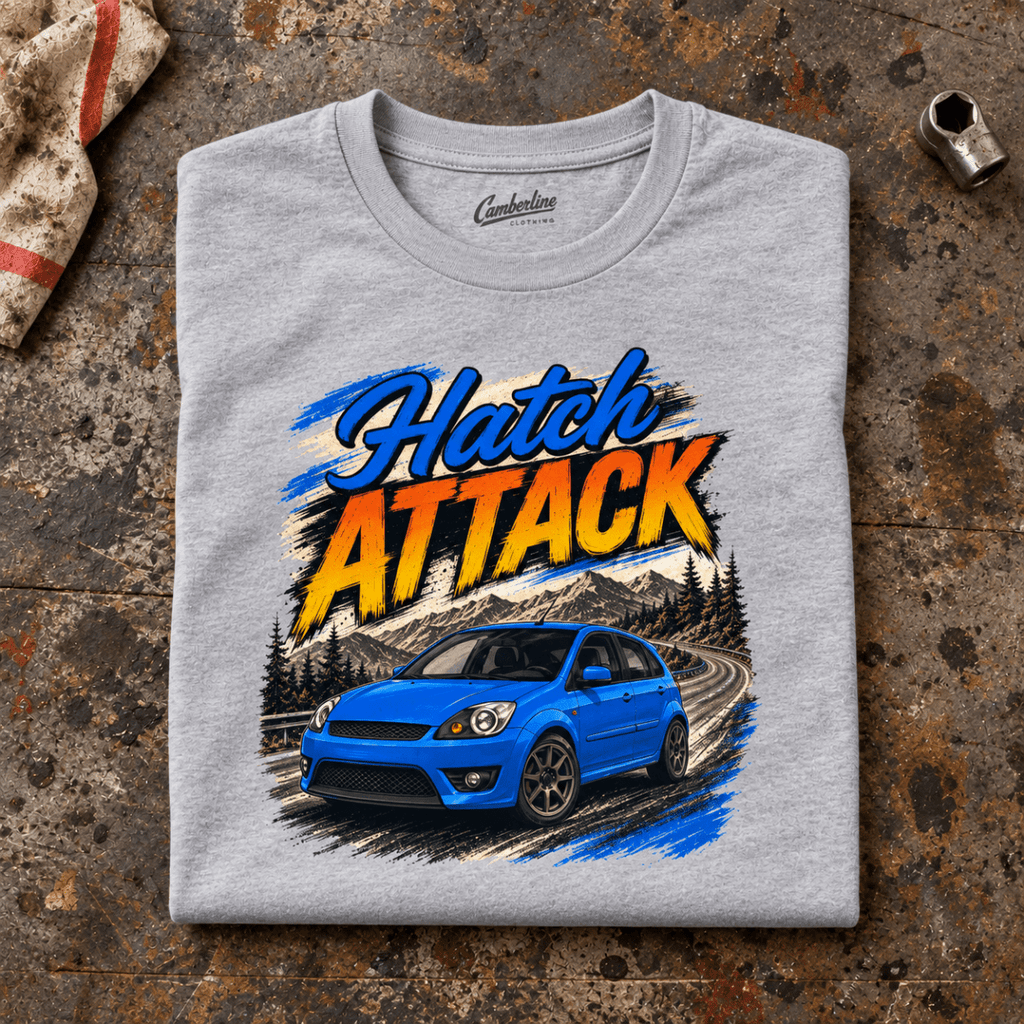 Hot Hatch Graphic T-Shirt – Hatch Attack Modern Performance, folded front main hero on a worn automotive workbench – car-ts-0014