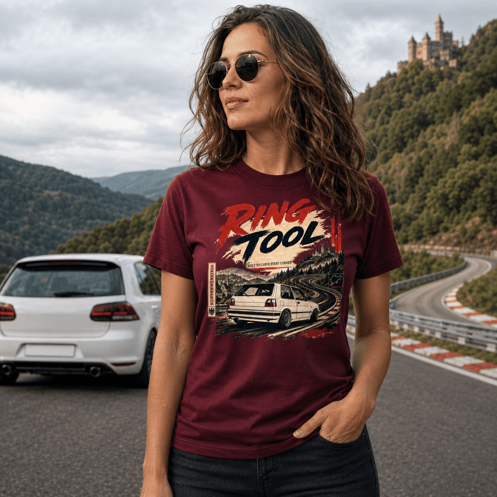 Lifestyle shot of a woman standing on a mountain road, wearing a burgundy  t-shirt featuring a bold text "Ring Tool"