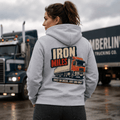 Person wearing a hoodie with a truck design and text in front of trucks
