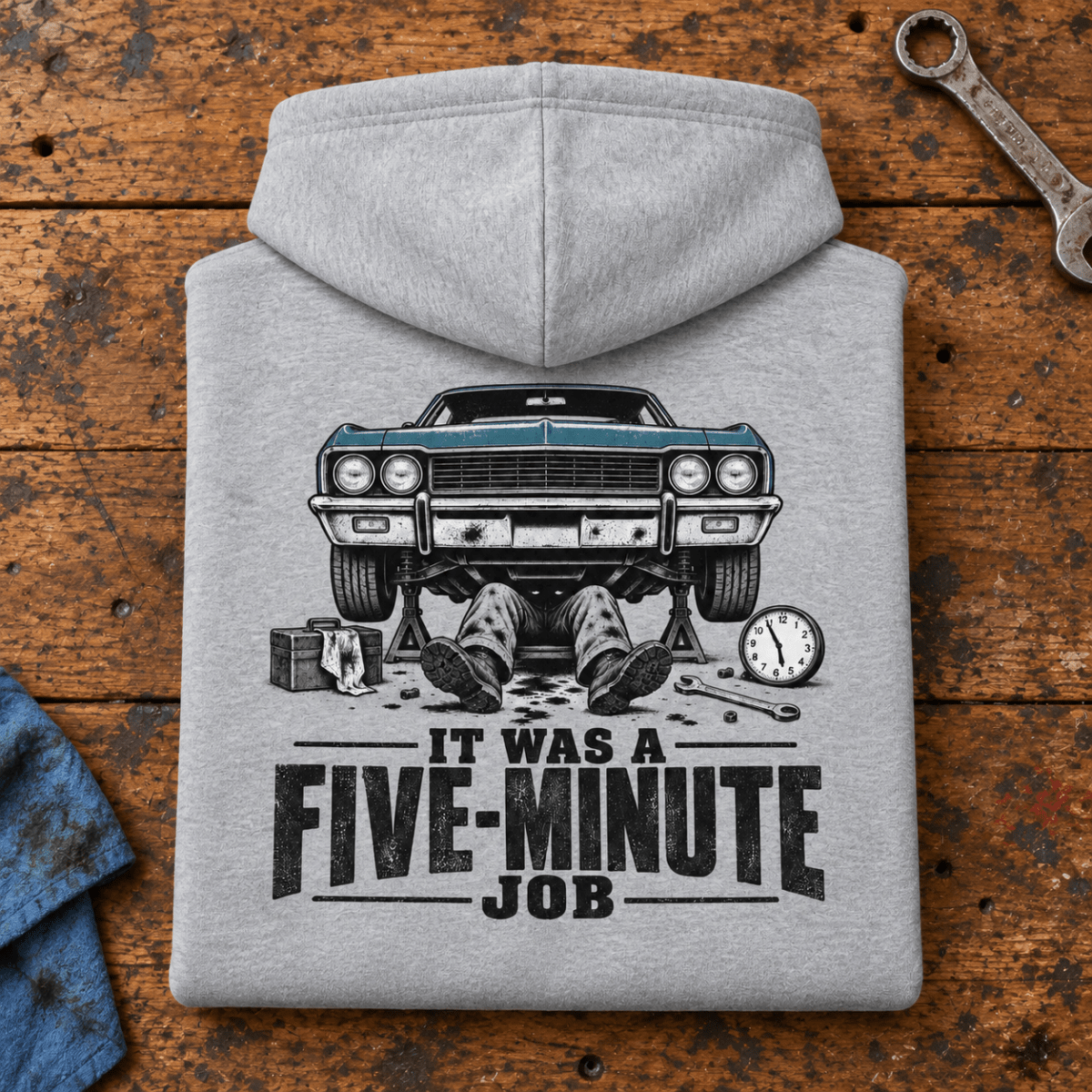 Camberline Classic Car Mechanic Hoodie in heather grey, folded back view on a workshop bench with full graphic visible