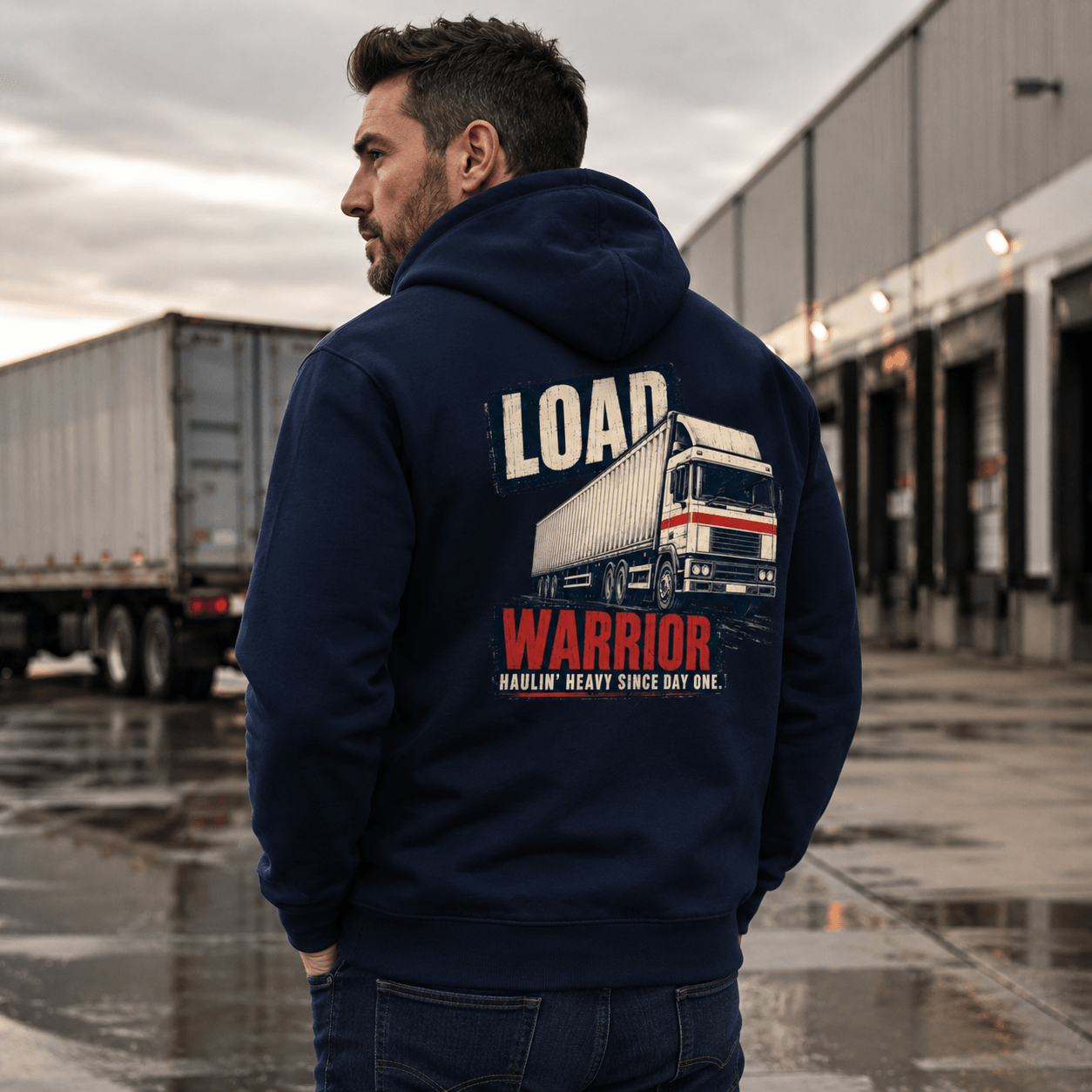 Man wearing a navy hoodie with 'Load Warrior' graphic in an industrial setting