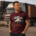 Male model wearing burgundy Load Warrior lorry t-shirt standing in a transport yard with artic lorry and shipping containers in the background