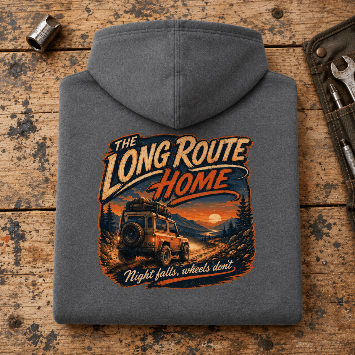 Camberline long route home 4x4 charcoal hoodie, folded rear view on a workshop bench with the complete graphic visible.
