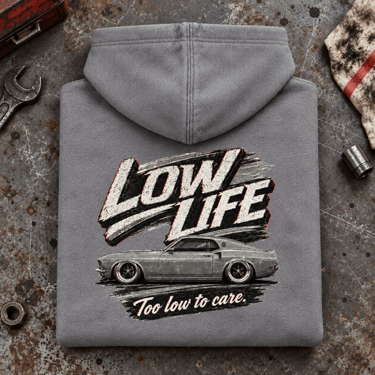 Low Life Monochrome Muscle Car Stance Graphic Hoodie — Heather Grey, folded back main hero on a worn automotive workbench – car-hd-0075