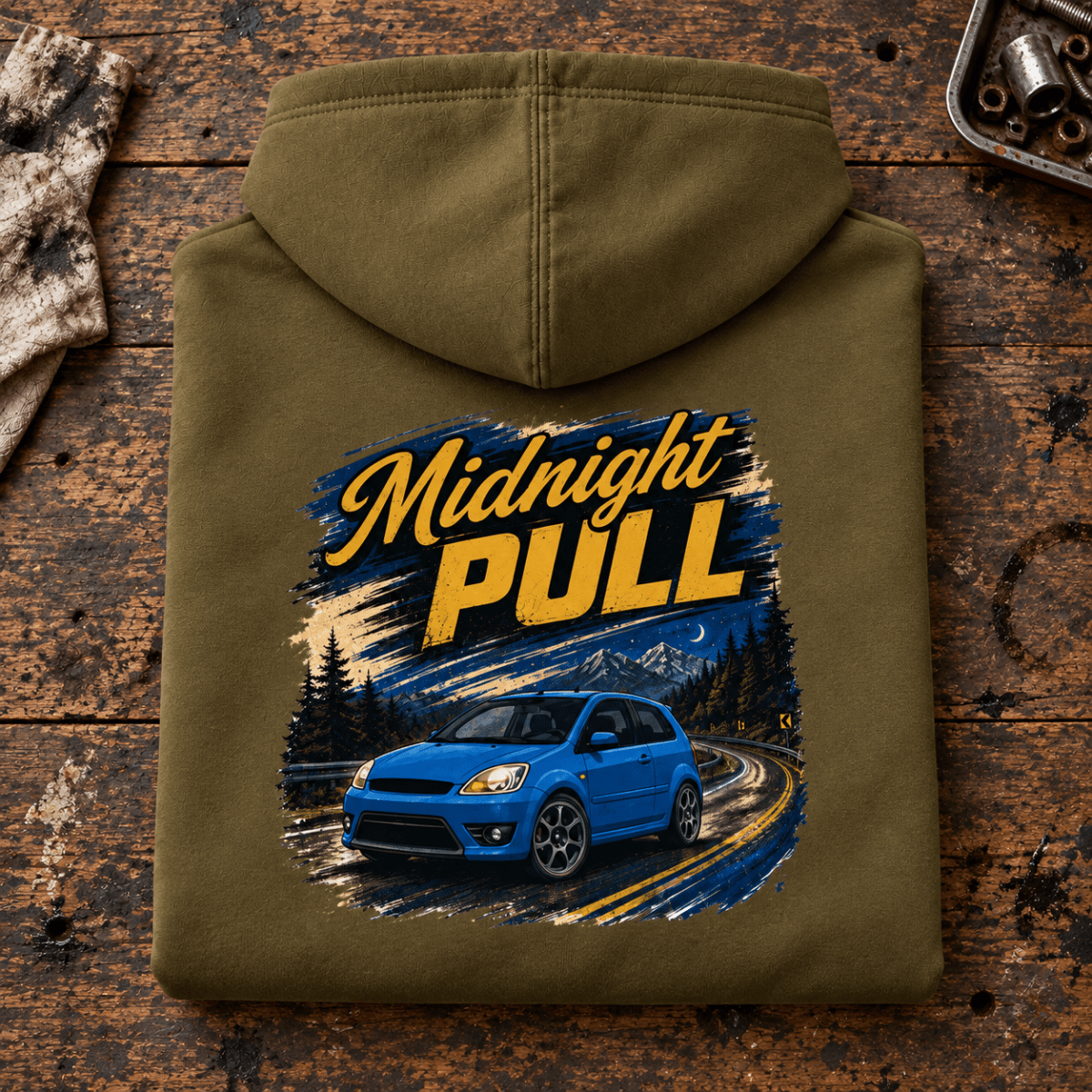 Hot Hatch Graphic Hoodie – Midnight Pull Night Drive, folded back main hero on a worn automotive workbench – car-hd-0019