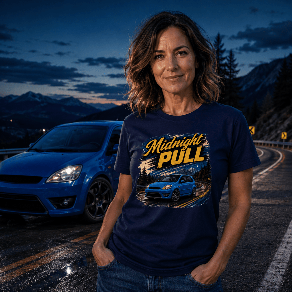Woman wearing a 'Midnight Pull' t-shirt standing on a mountain road with a blue car.
