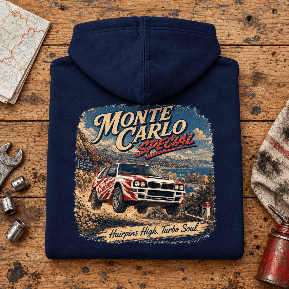 Folded navy monte carlo special rally hoodie, rear print on a worn workshop bench — car-hd-0044