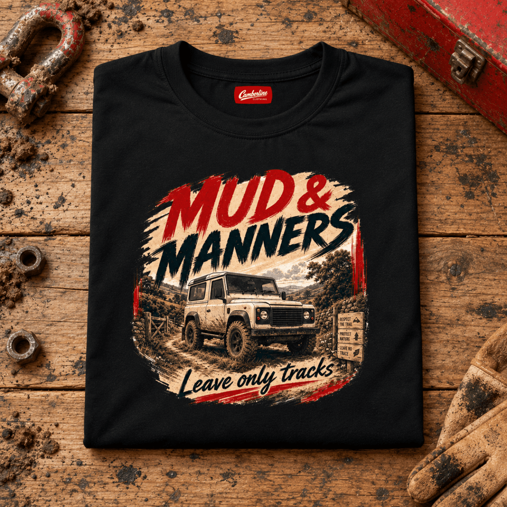 Camberline mud and manners 4x4 black T-shirt, folded front view on a workshop bench with the complete graphic visible.