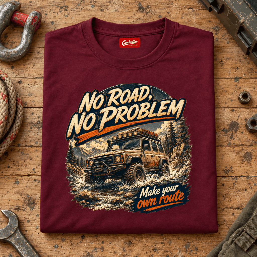 Folded maroon No Road No Problem Adventure T-shirt front on a workshop bench — car-ts-0090
