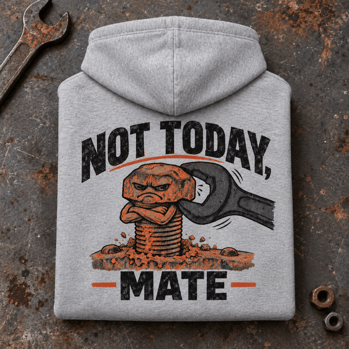 Camberline Stubborn Bolt Mechanic Hoodie in heather grey, folded back view on a workshop bench with full graphic visible
