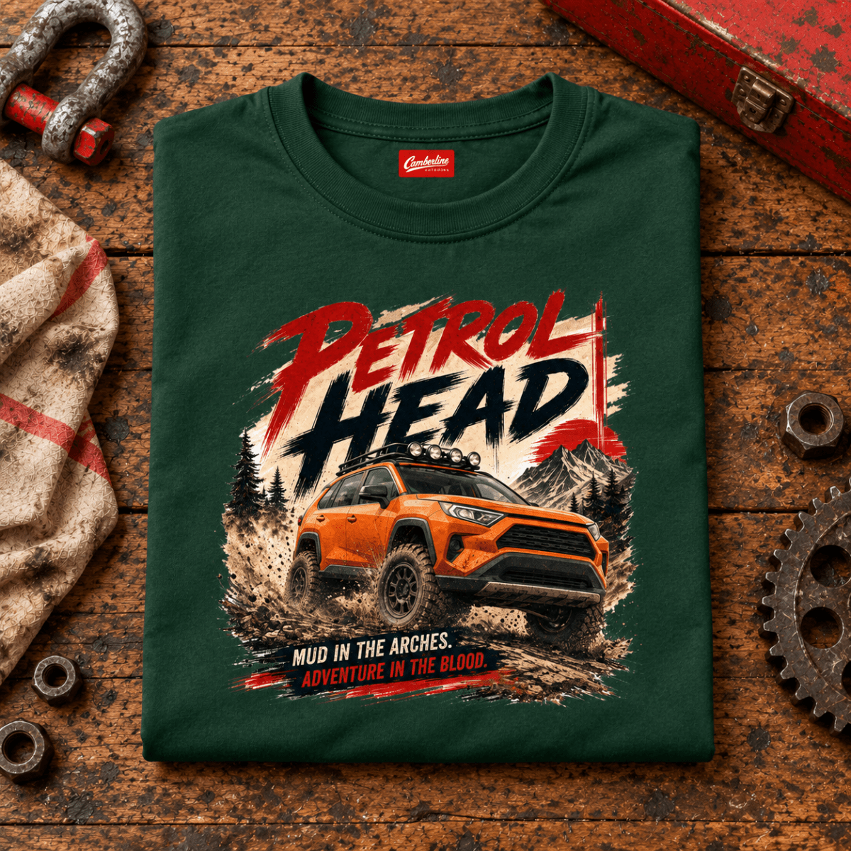 Folded forest green petrol head orange suv T-shirt, front print on a worn workshop bench — car-ts-0007