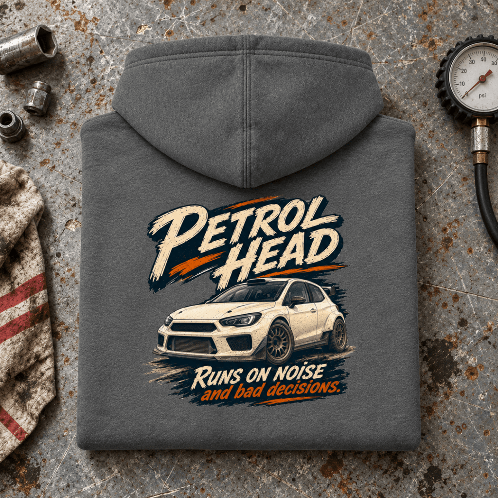 Rally Car Graphic Hoodie – Hatchback Motorsport Charcoal, folded back hero on a worn automotive workbench – car-hd-0077