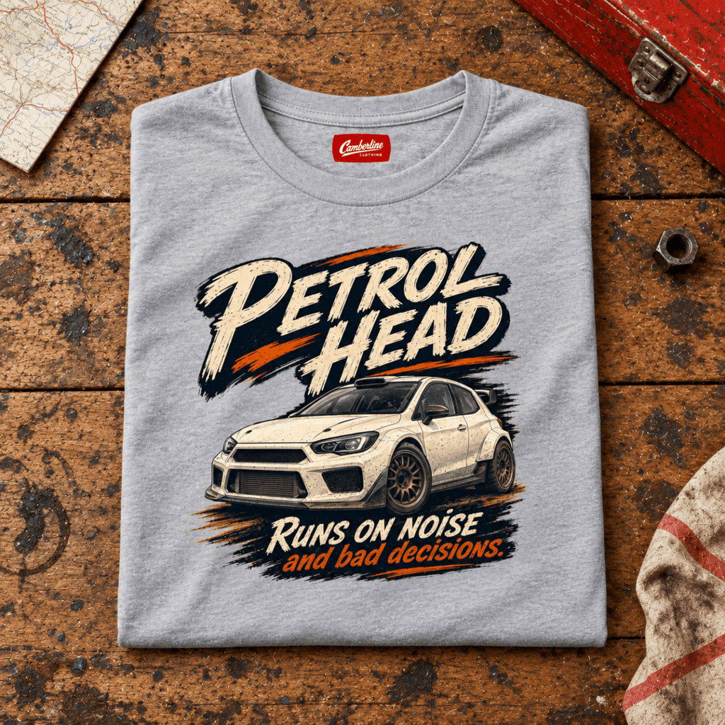 Rally Car Graphic T-Shirt – Hatchback Motorsport, folded front main hero on a worn automotive workbench – car-ts-0077