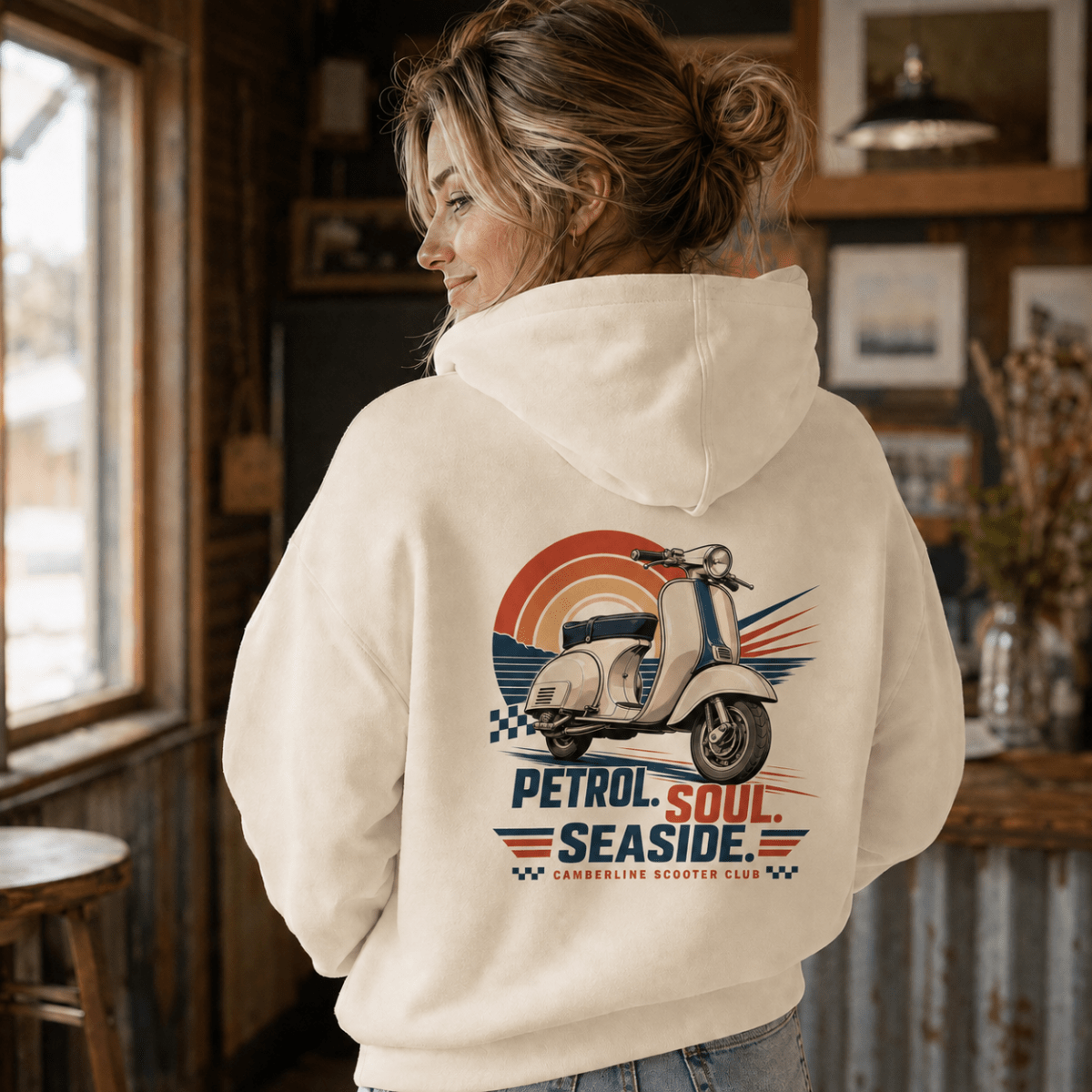 Model wearing a cream Petrol Soul Seaside vintage scooter graphic hoodie, back print view