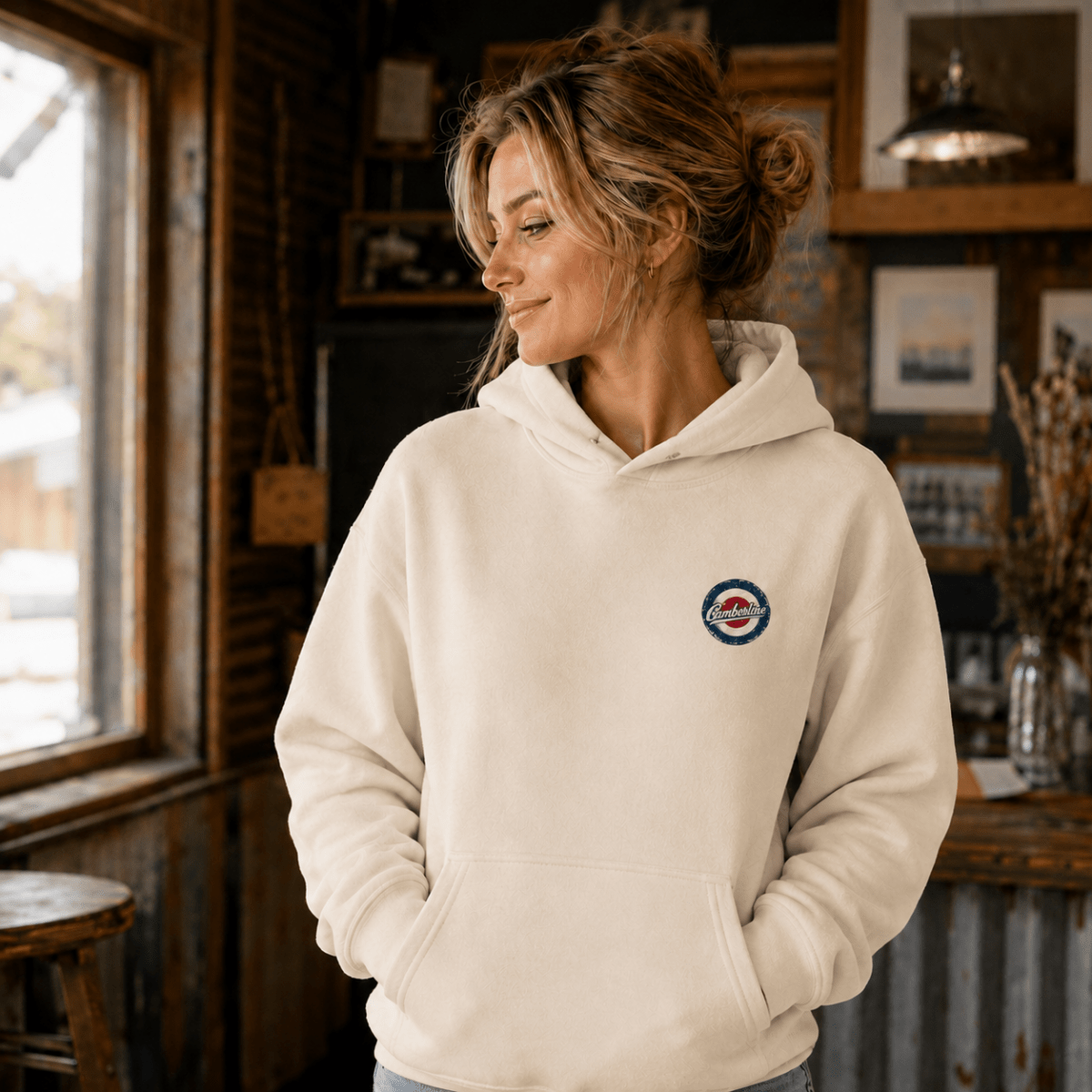 Front view of model wearing the cream Camberline hoodie with left-chest print