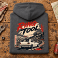 Hot Hatch Graphic Hoodie – Ring Tool Nürburgring Mk2 Track Day Line Art, folded back main hero on a worn automotive workbench – car-hd-0043
