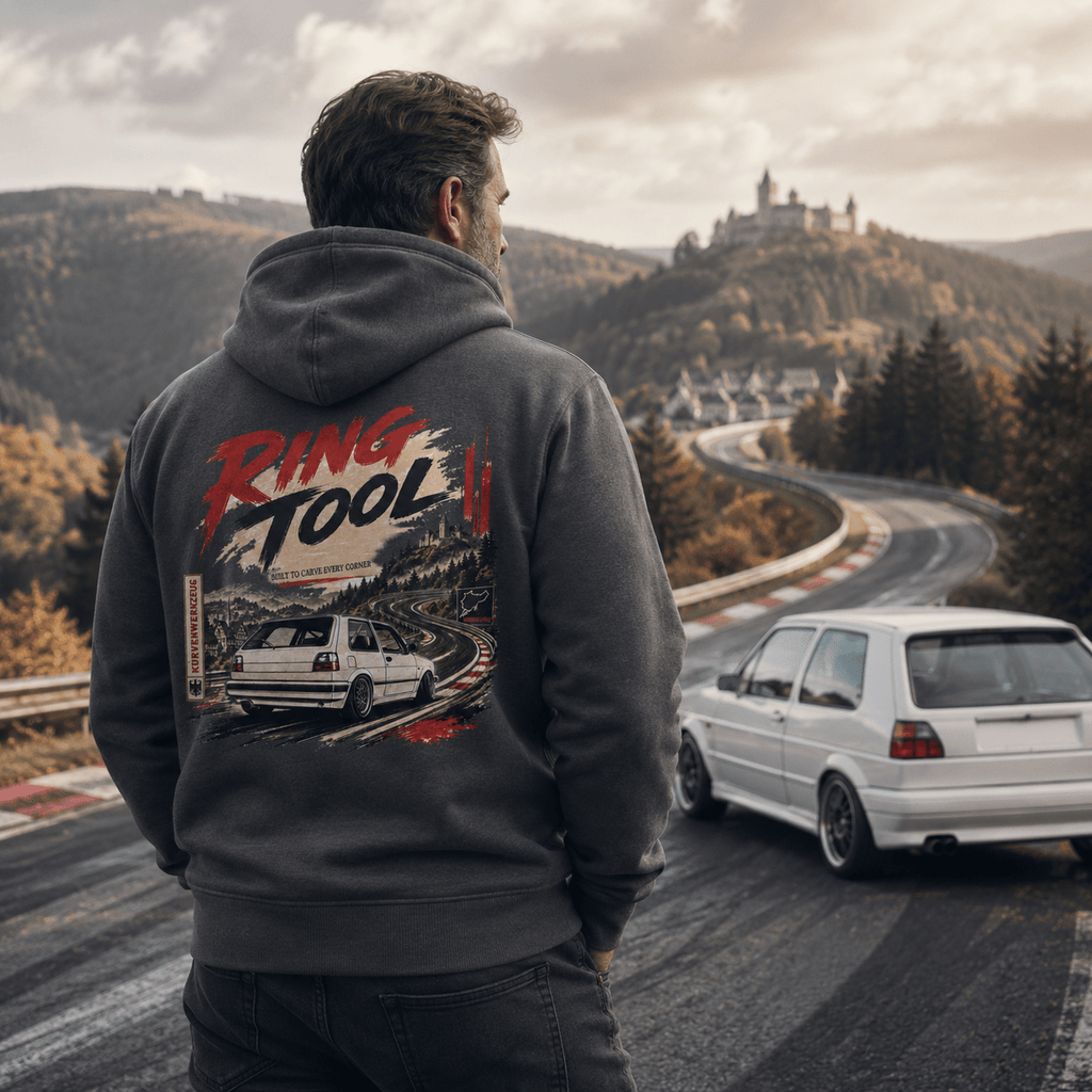 Man wearing a hoodie with 'Ring Tool' design, standing on a winding road with a car in the background.