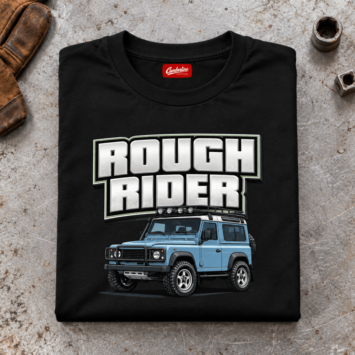 Folded black Rough Rider T-shirt front on a workshop bench — car-ts-0001