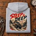 Folded heather grey Steep And Deep Hill Descent hoodie back on a workshop bench — car-hd-0092