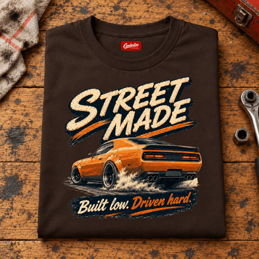 Folded dark chocolate Street Made Custom Build T-shirt front on a workshop bench — car-ts-0086