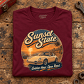 Classic Sports Car Graphic T-Shirt – Sunset State Classic, folded front main hero on a worn automotive workbench – car-ts-0069