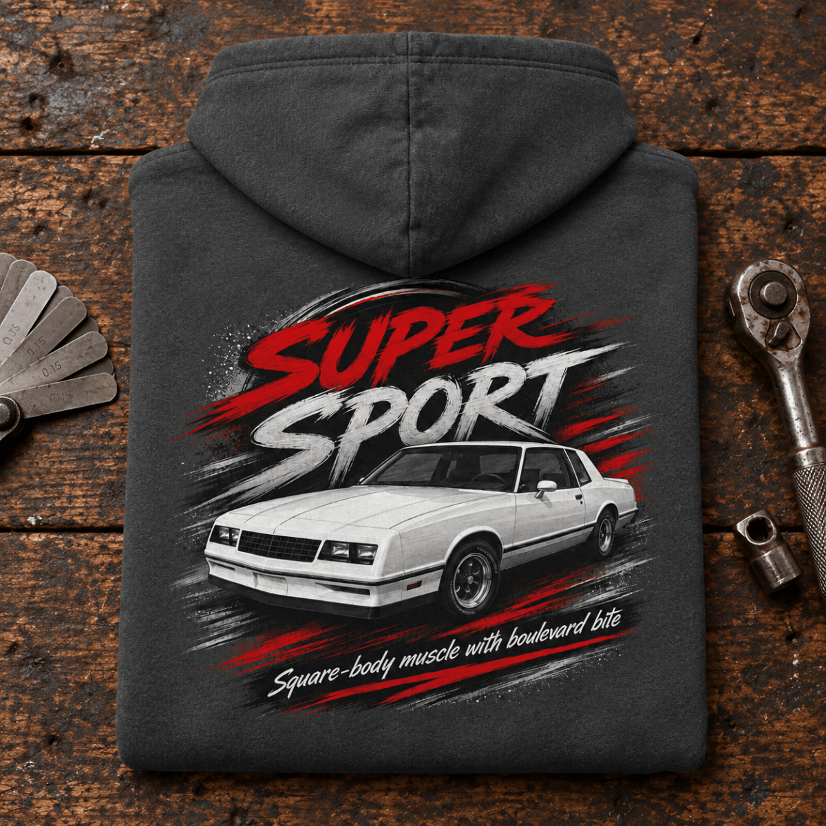 Super Sport Square-Body Muscle Coupe Graphic Hoodie – Dark Grey, folded back hero on a worn automotive workbench – car-hd-0152
