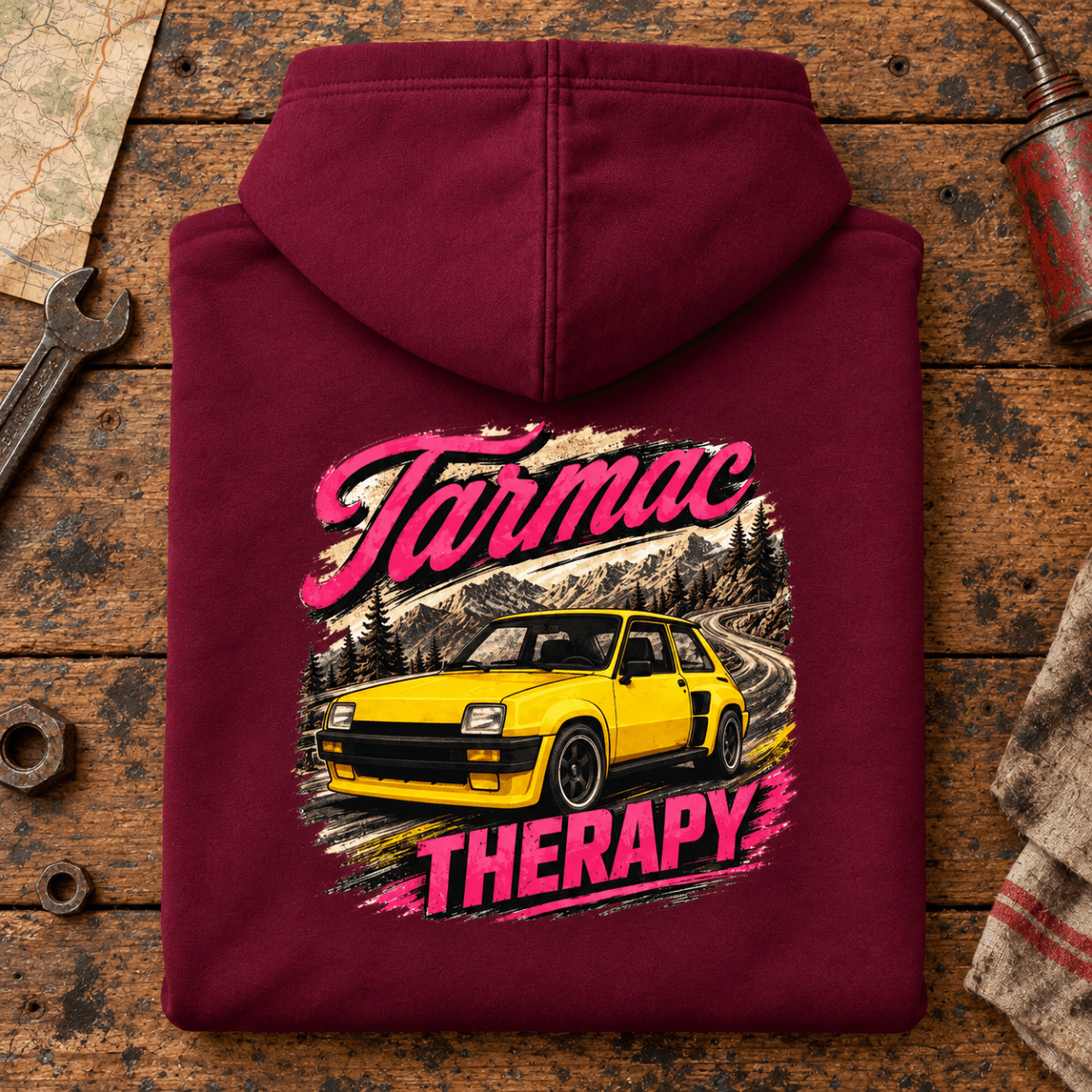 Hot Hatch Graphic Hoodie – Tarmac Therapy Yellow Mountain Road, folded back main hero on a worn automotive workbench – car-hd-0013