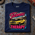 Muscle Car Graphic T-Shirt – Tarmac Therapy Yellow Car, folded front main hero on a worn automotive workbench – car-ts-0017