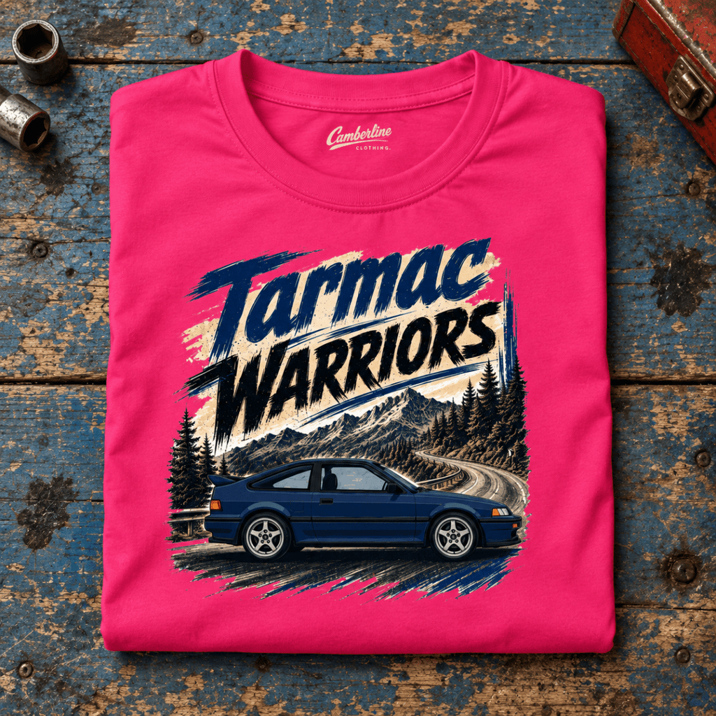 Classic Coupe Graphic T-Shirt – Tarmac Warriors Blue JDM Retro Mountain Pass, folded front main hero on a worn automotive workbench – car-ts-0016