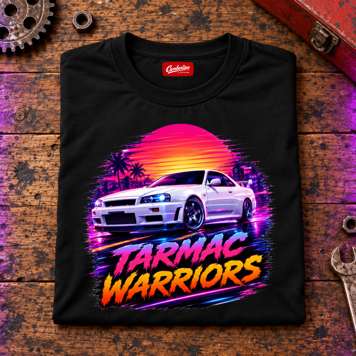 JDM Car Graphic T-Shirt – Tarmac Warriors Retrowave Neon, folded front main hero on a worn automotive workbench – car-ts-0023