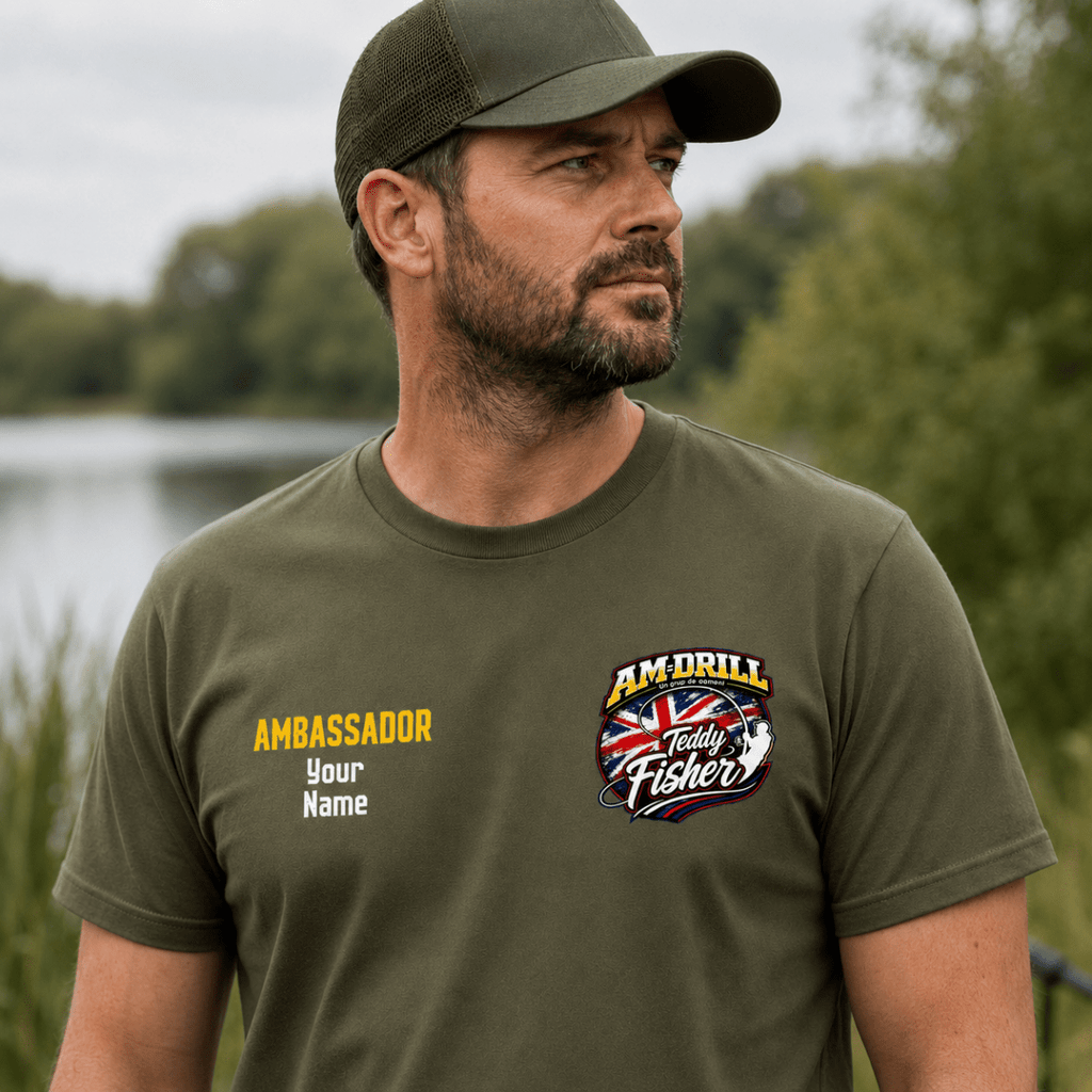 Man standing outdoors by the water wearing olive green branded fishing t-shirt
