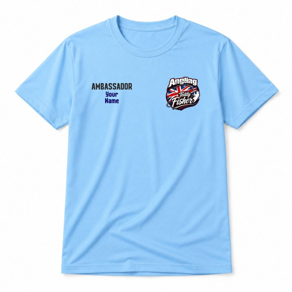 A light blue short-sleeve t-shirt with a graphic on the left chest. The graphic features the word 'AMBASSADOR' in black, followed by 'Your Name' in blue, indicating a customizable print.