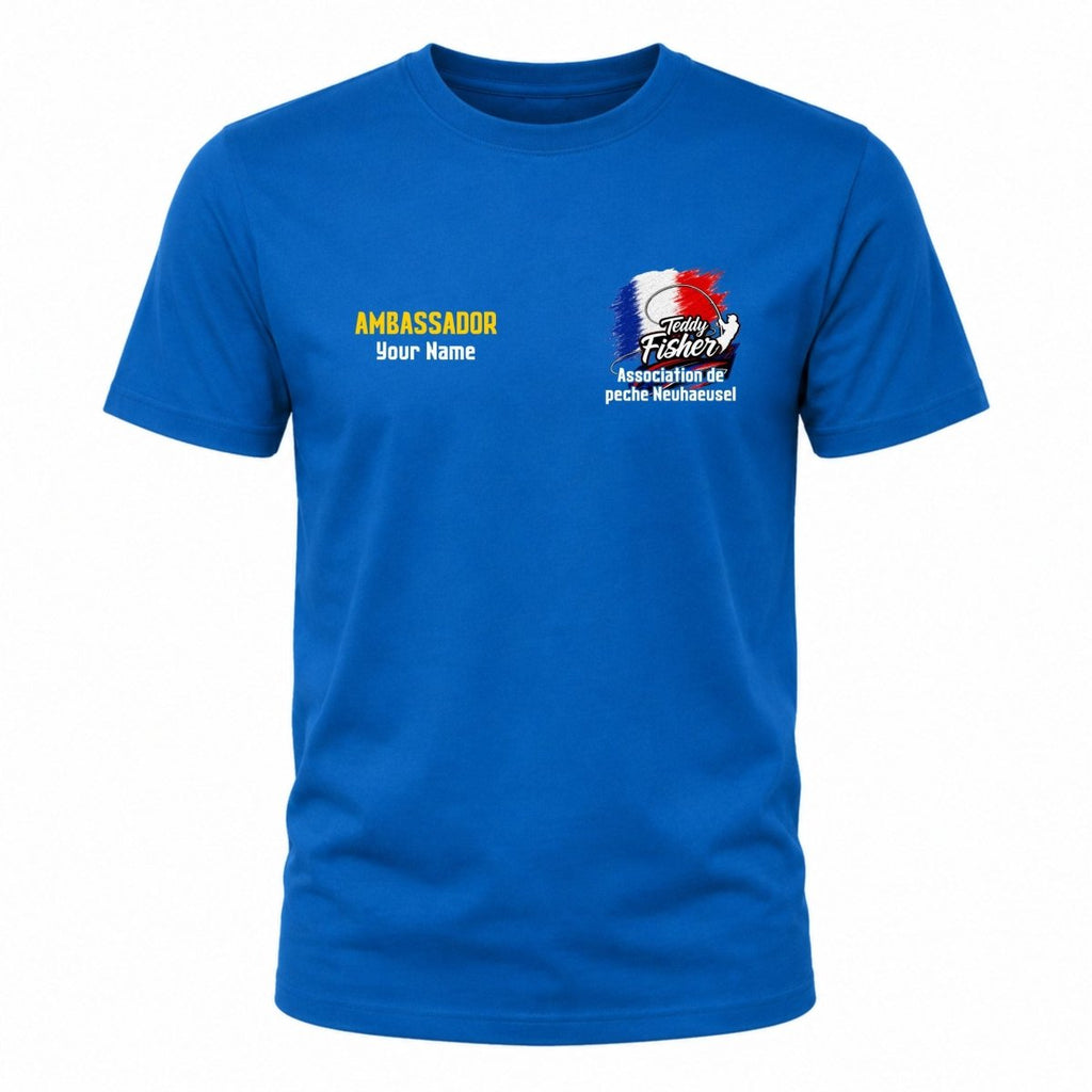 A royal blue short-sleeve crewneck t-shirt displayed on a solid white background. The left chest features yellow text reading 'AMBASSADOR' and 'Your Name' below it, while the right chest displays a colorful graphic with a French flag, a fishing rod, and the text 'Sandy Fishing' and 'Moulinet des pêche Meshaweel'.