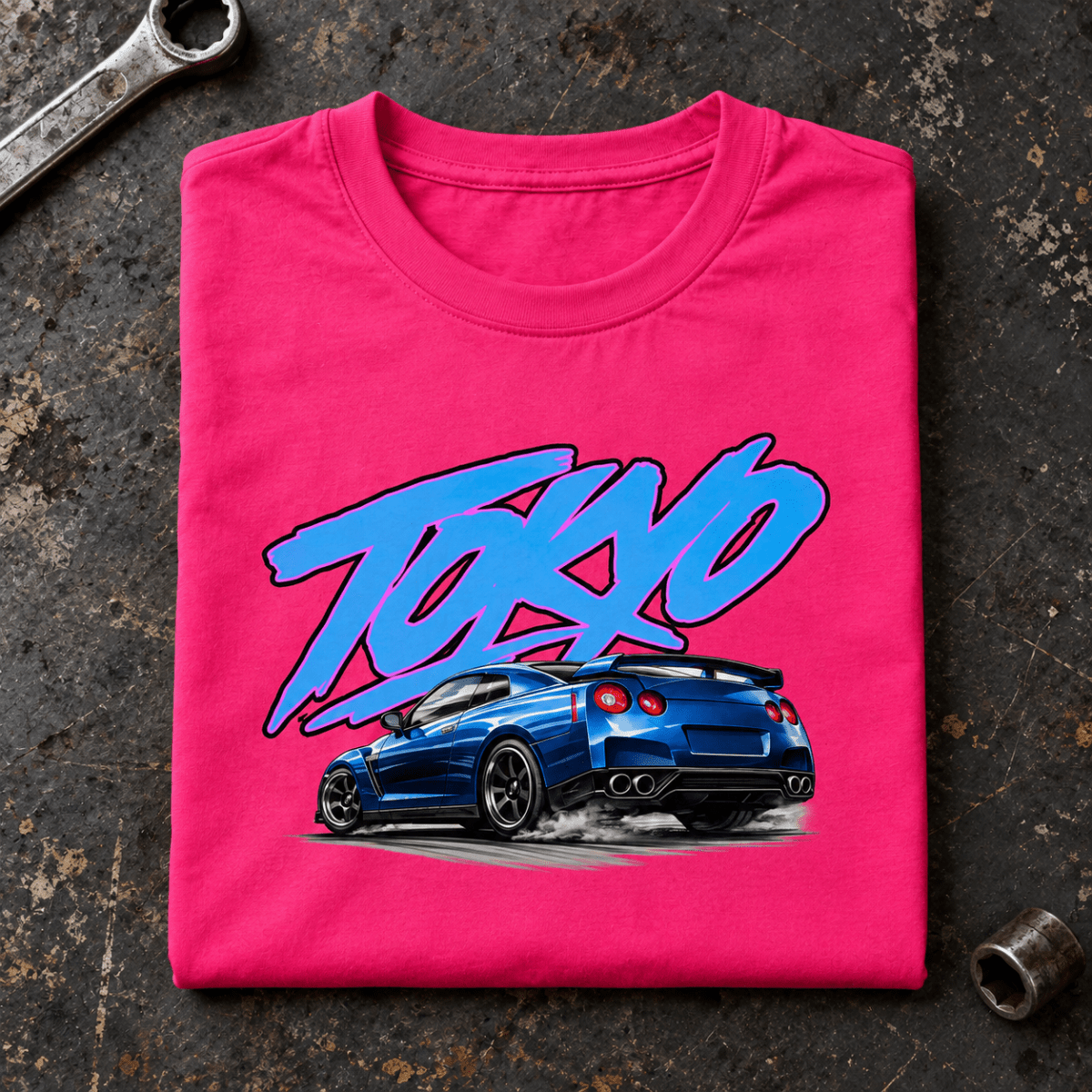 Camberline JDM Car Graphic T-Shirt in hot pink, folded front view on a workshop bench with the full graphic visible