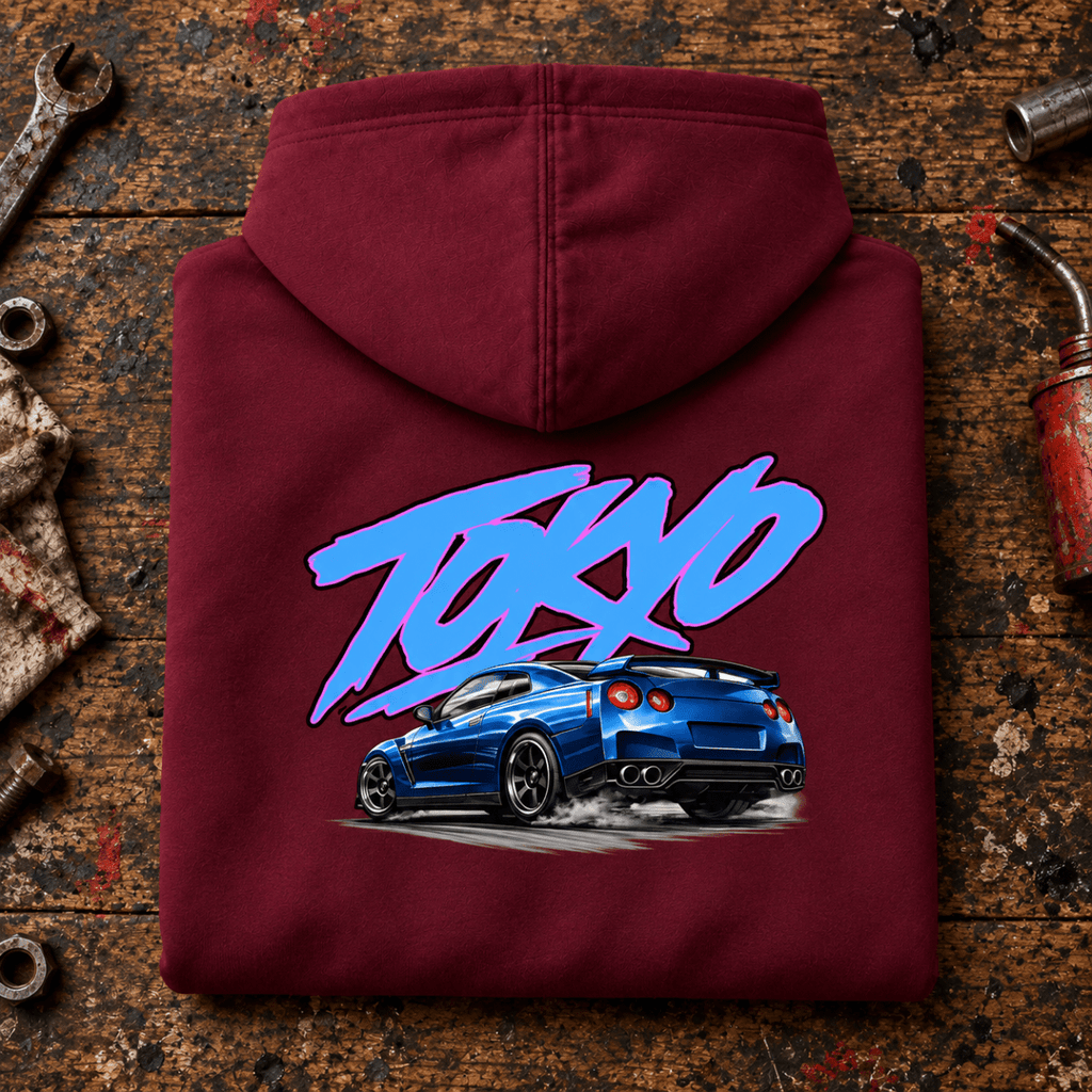 JDM Car Graphic Hoodie – Tokyo Blue Sports Car, folded back main hero on a worn automotive workbench – car-hd-0040
