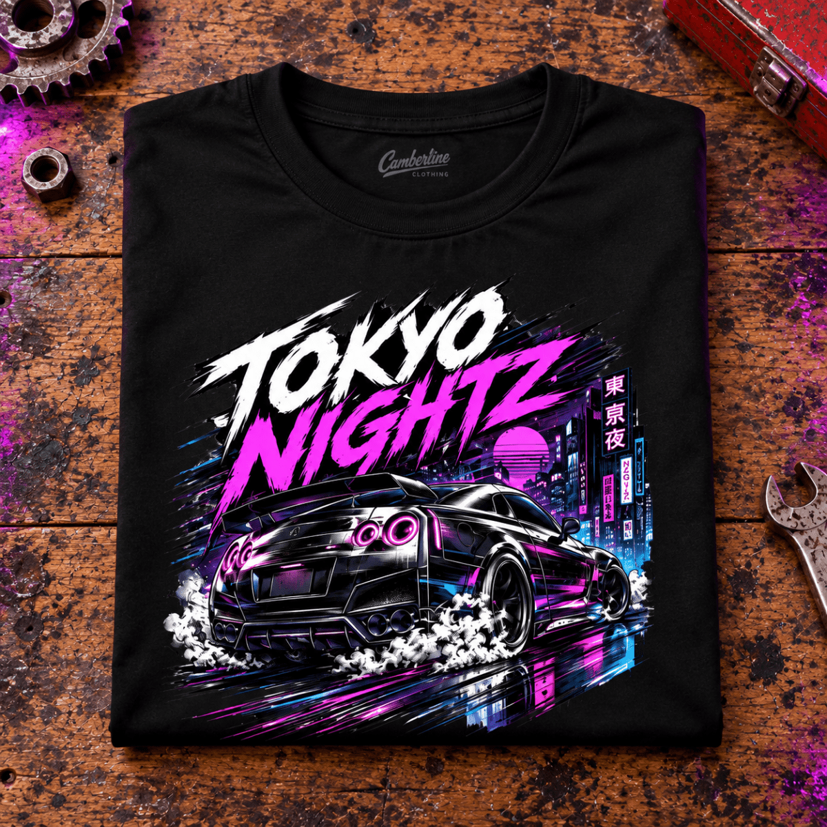 JDM Car Graphic T-Shirt – Tokyo Nightz Drift Neon City, folded front main hero on a worn automotive workbench – car-ts-0033